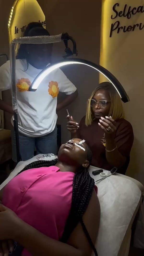 Lash application is demonstrated on a model while a student observes.